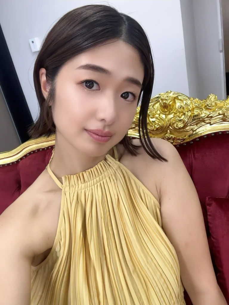 Nanami Kawakami ในชุดสีเหลืองบนเก้าอี้กำมะหยี่สีแดง